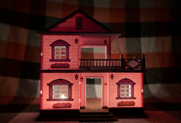 istock Small toy house in the dark, lit by candlelight 1449358721