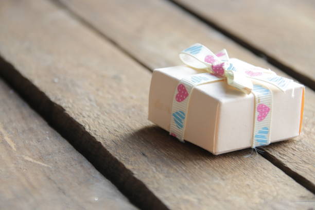 Gift with a ribbon on a beautiful wooden vintage background.