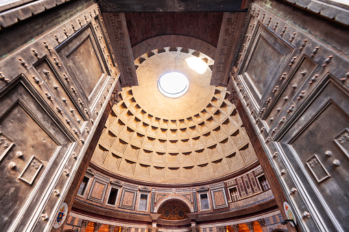 The sun shining through the domed ceiling of the Roman Pantheon.