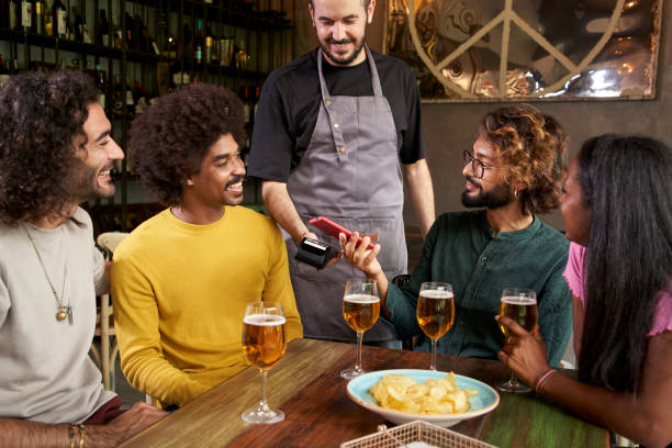 istock Customer making wireless or contactless payment using smartphone in a bar 1449363179