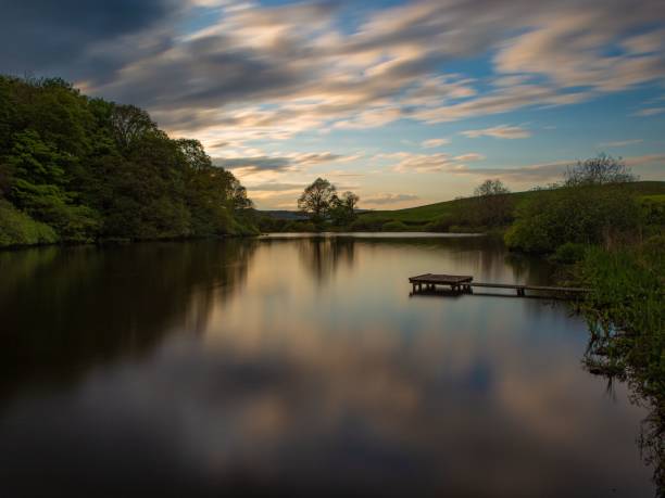 istock Landscape view with a lake reflectin sky and trees at sunset 1449367711