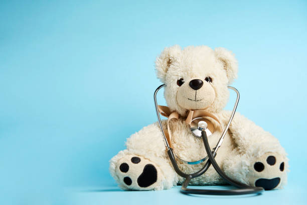 istock Teddy bear toy and medical stethoscope on a blue background 1449367804