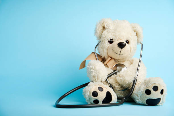 istock Teddy bear toy and medical stethoscope on a blue background 1449367816