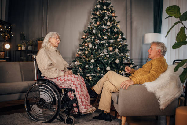 istock Senior couple drinking wine next to Christmas tree at home 1449369031