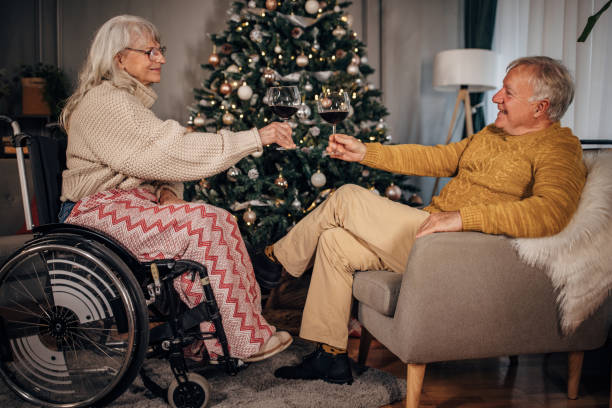 istock Senior couple drinking wine next to Christmas tree at home 1449369331