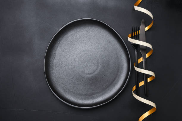 istock Festive table setting black plates and gold decor on black Background, invitation dinner birthday party anniversary. top view copy space 1449373380