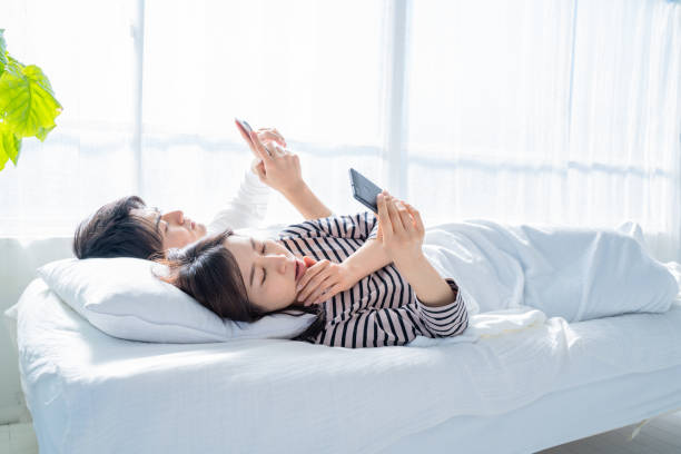 istock Couple looking at smartphone in bed. 1449374208