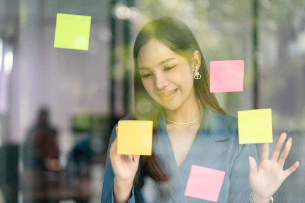 istock Young confident Businesswoman planning with adhesive notes in creative office. 1449374427