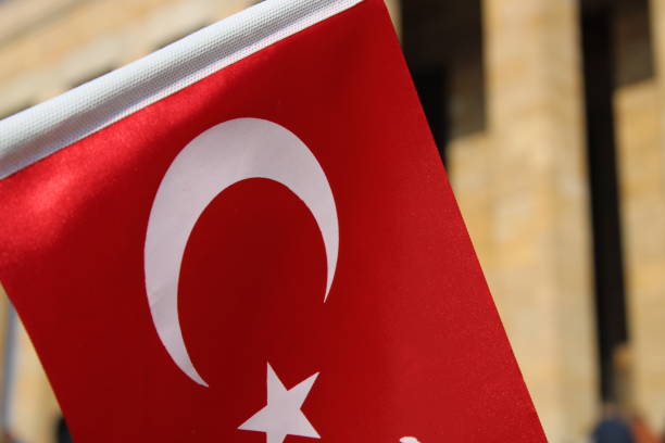 istock hand holding turkish flag on mausoleum background 1449375535