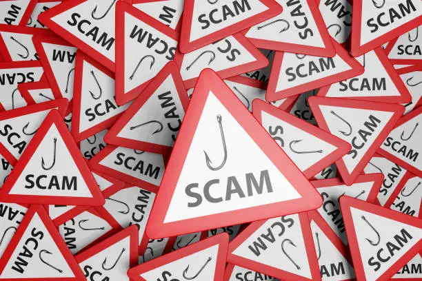 Photo of Red warning triangle with white background and black symbol showing a fishing hook and the word SCAM. Illustration of the concept of cyber scam and email phishing