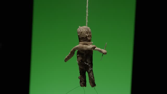 A voodoo doll on a green background