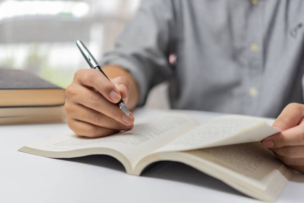 istock Businessperson reading and writing on book.education studying knowledge development and cognition learning concept. 1449381528