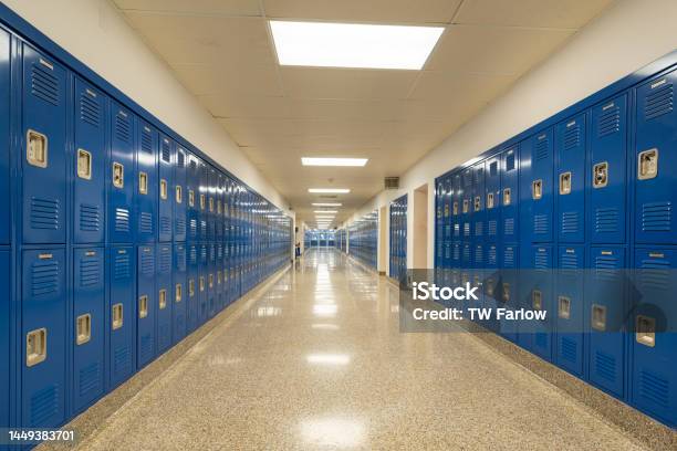 Typical Nondescript Usa Empty School Hallway With Royal Blue Metal Lockers Along Both Sides Of The Hallway Stock Photo - Download Image Now