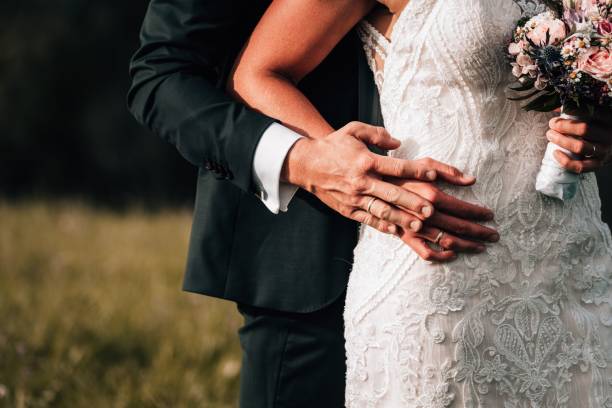 istock Vertical closeup of a groom hugging bride from back 1449386254