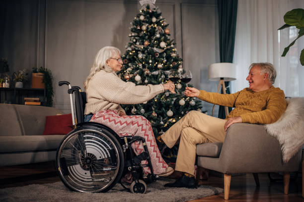 istock Senior couple drinking wine next to Christmas tree at home 1449386419