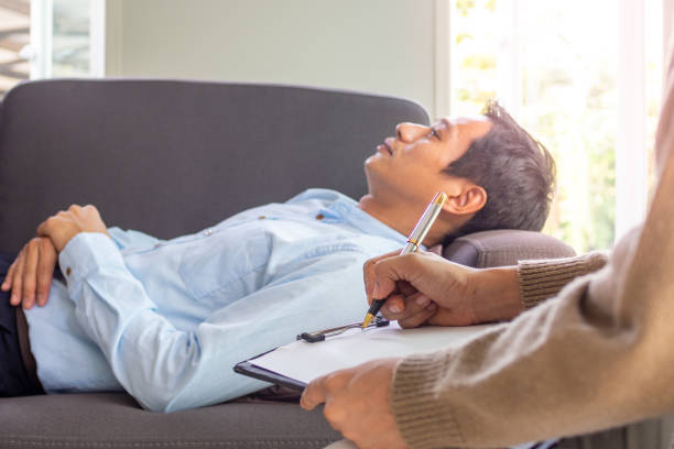 l’homme atteint de maladie mentale dort avec une posture détendue, consulte et écoute les directives pour résoudre la maladie du psychiatre. - mannered photos et images de collection