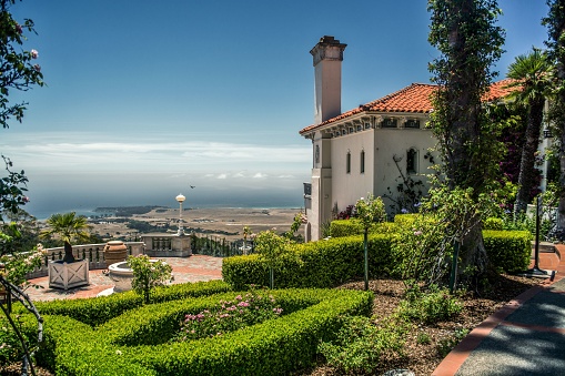 San Simeon, United States – June 23, 2013: A beautiful garden of and old-fashioned luxury house with an ocean view