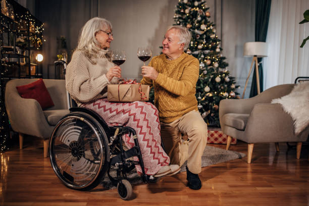 istock Senior couple drinking wine next to Christmas tree at home 1449391387