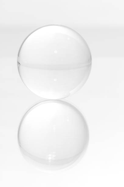 istock Glass ball on a mirrored surface and white background. 1449391718