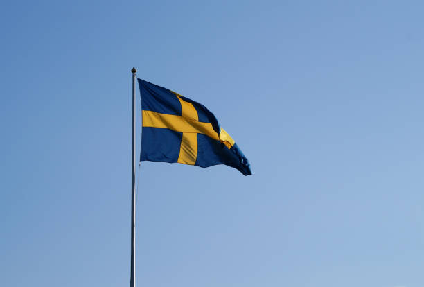Low angle view of flag against clear blue sky