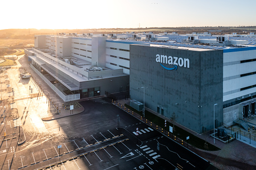 Leeds, UK - December 14, 2022.  An aerial view of a newly built Amazon Prime warehouse with sign in Leeds, West Yorkshire at sunrise