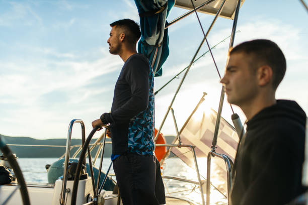 istock Two young men sailing on a sailboat 1449392922