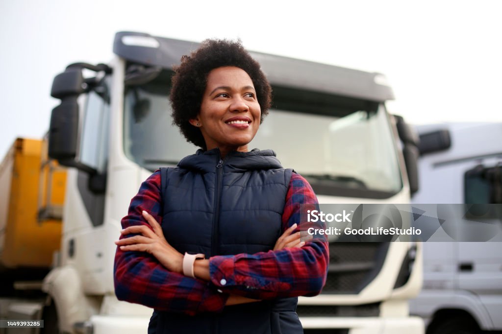 Smiling truck driver Mid adult female truck driver. About 40 years old, African woman. Truck Driver Stock Photo
