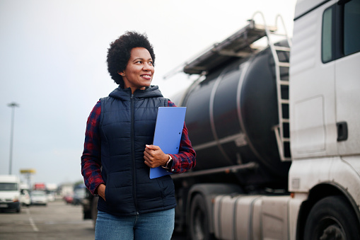Mid adult female fuel truck driver. About 40 years old, African woman.