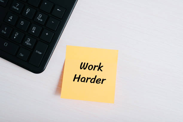 istock Sticker memo Work harder pasted in workplace, top view. Motivation concept 1449395675