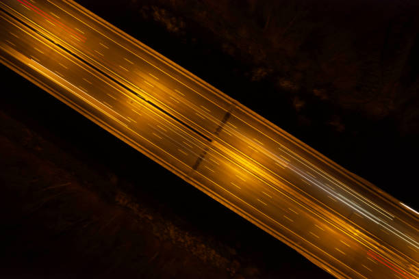 istock highway road in the forest at night (aerial) 1449396525