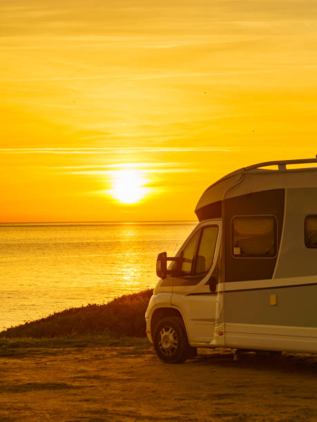 istock Camper vehicle on beach at sunrise 1449397002