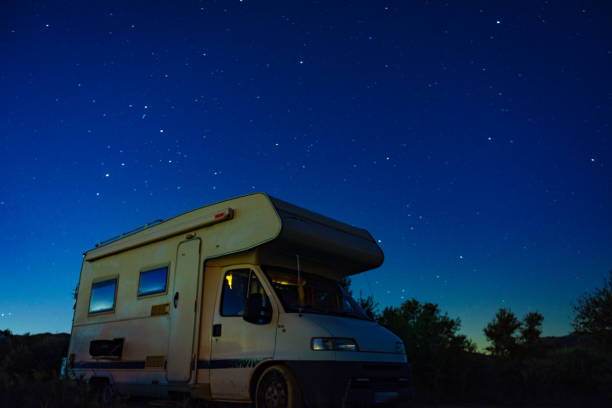 istock Night starry sky and camper rv. 1449397740