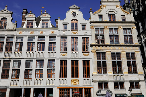 Brussels, Belgium - September 16, 2022: The sunlit historic houses are from left to right: Le Petit Renard , Le Paon , Le Heaume located on Grand Place in the central part of the city
