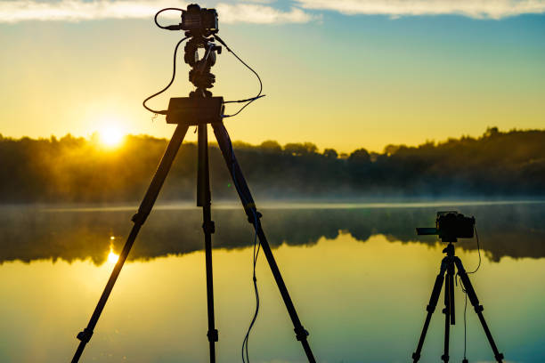 istock Camera on tripod take photo from sunrise over lake 1449401196