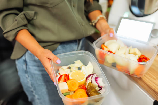 istock Unrecognizable cropped woman hands hold two container box with fresh fruit and vegetables.Portions in disposable boxes 1449402902