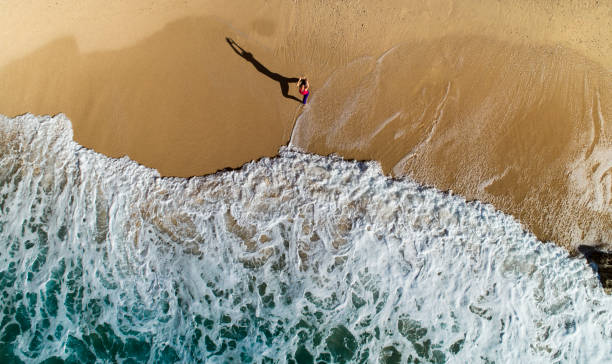 istock Aerial view woman practicing yoga at the beach 1449404170