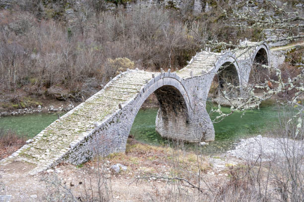 istock Greece Epirus. Plakida or Kalogeriko ancient three arched stone bridge, dry nature background. 1449406910