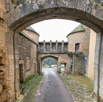 Looking down the old street to the Porte du Val, an old gate and village wall. The small medieval village is classified as one of the most beautiful villages in France (plus beaux villages de France). 01/07/2022 -Rue de l'Église, 21150 Flavigny-sur-Ozerain, Department Côte-d'Or, Burgundy-Franche-Comté, Arrondissement Montbard, France