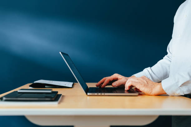 istock Side View Of An Anonymous Businessman Using Laptop Computer At Home 1449412166