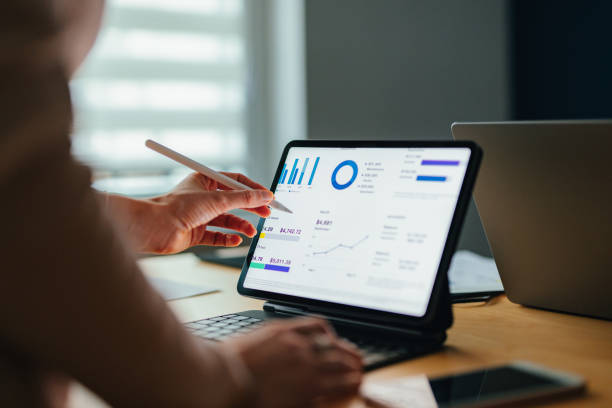 istock Unrecognizable Businesspeople Analyzing Business Graph On A Digital Tablet And Laptop Computer 1449413026