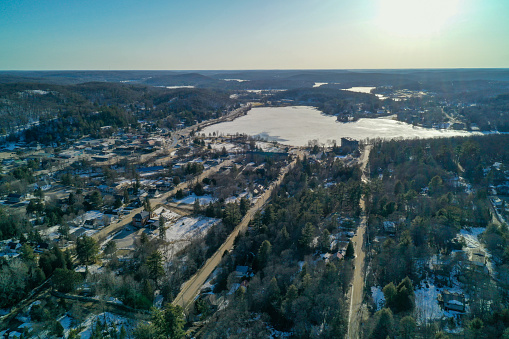 Haliburton Village with roads, trees, frozen Drag Lake and sunny horizon in the winter/spring