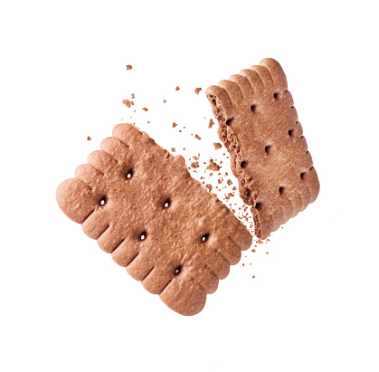 Delicious biscuit with chocolate flavor crushed into two halves in the air close-up isolated on a white background