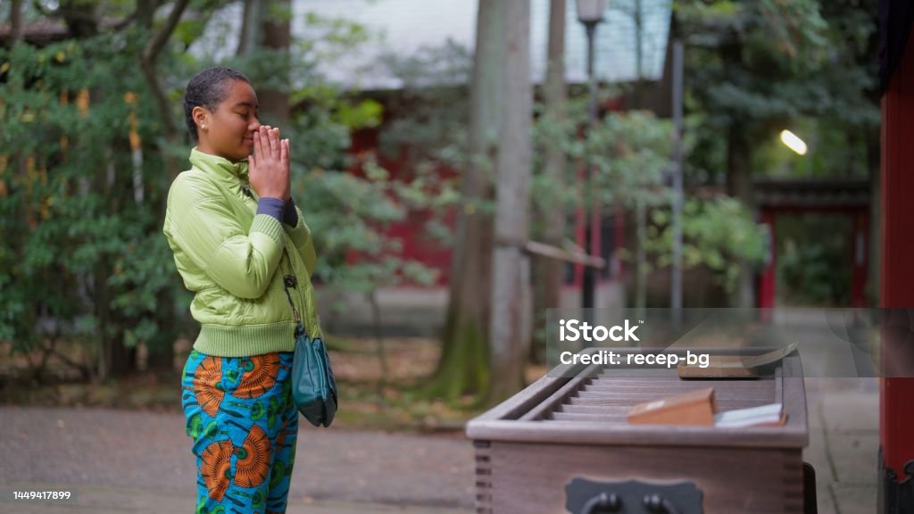 Female tourist visiting shrine and praying A female tourist is visiting a shrine and praying. 20-24 Years Stock Photo