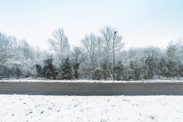 schneebedeckte straße england - drivers point of view country road snowing blizzard stock-fotos und bilder