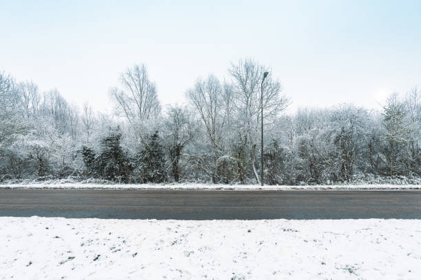 Snow covered road England Snow covered road England car-on-city-road-side-view stock pictures, royalty-free photos & images