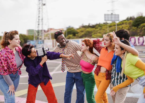 istock Group of multiracial young people having fun together outdoor while using vintage video camera 1449418136