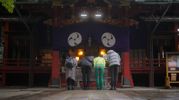 Group of multiracial friends visiting shrine and praying A group of multiracial friends are visiting a shrine and praying. shinto stock pictures, royalty-free photos & images