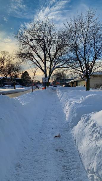 istock Vertical view a snowy sidewalk on a sunny day in winter 1449419419