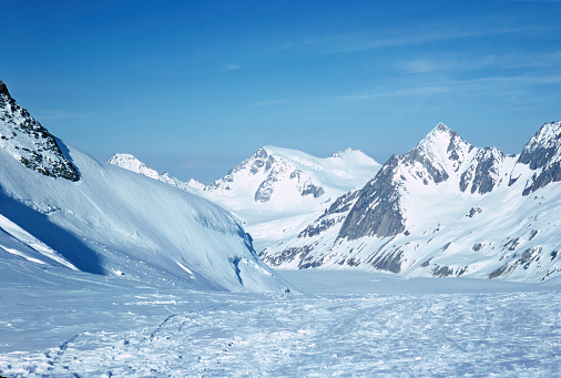 Panorama of snowy mountains and high alpine peaks in wintery Bernese Oberland in Switzerland