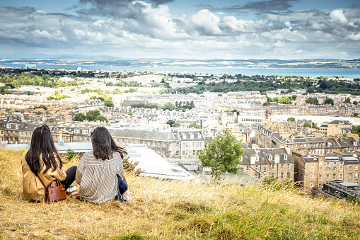 Edinburgh, Scotland - July 14, 2022:  Two girls admire the view of Edinburgh city from the Calton Hill.